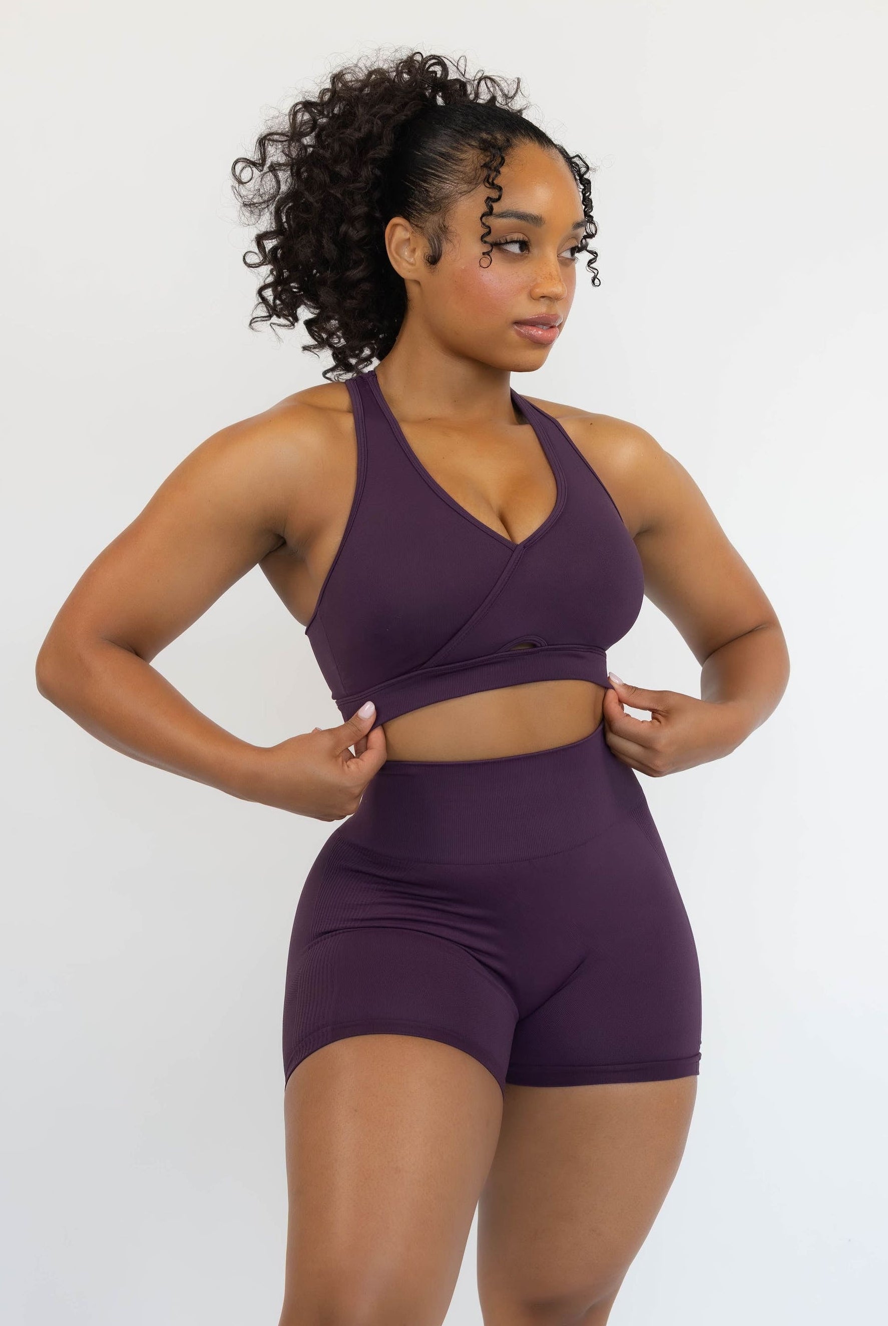 Woman wearing a purple athletic outfit on a white background