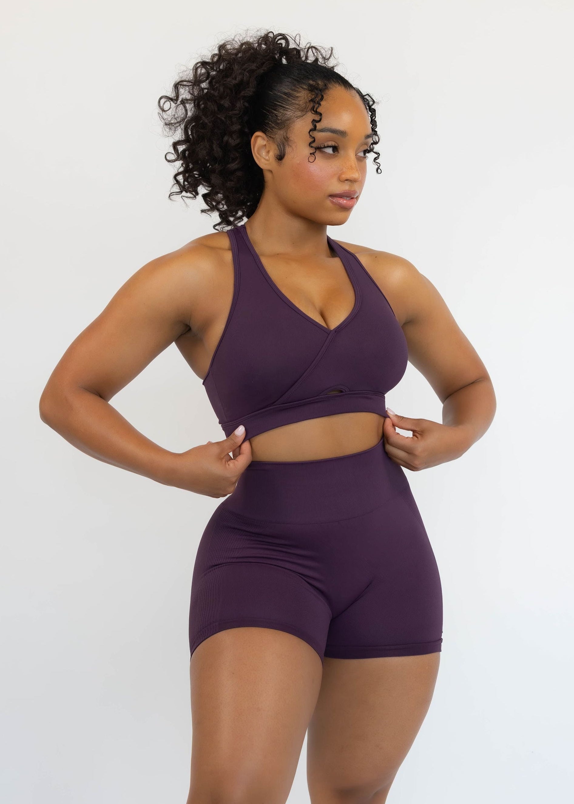 Woman wearing a purple athletic outfit on a white background