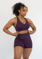 Woman wearing a purple athletic outfit on a white background