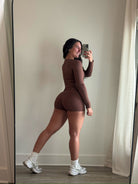 Person taking a mirror selfie wearing a brown outfit with white sneakers.